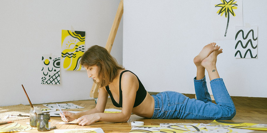 woman lying on the floor while painting