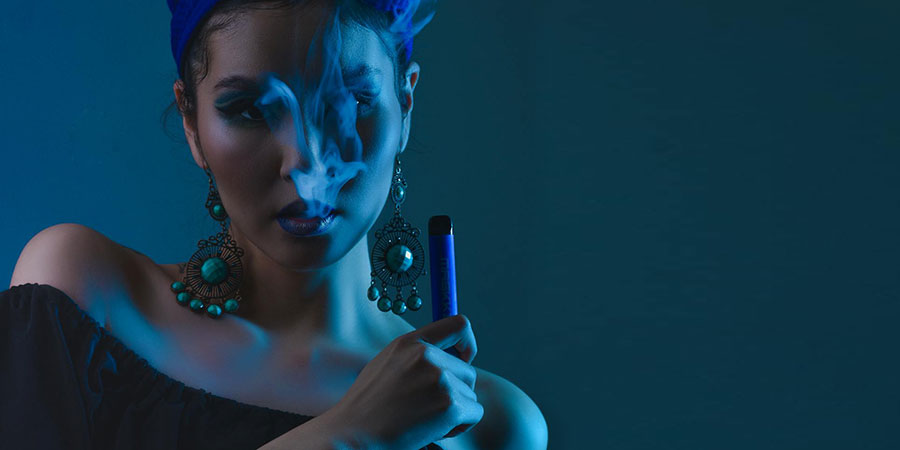 a woman in black top holding an electronic cigarette
